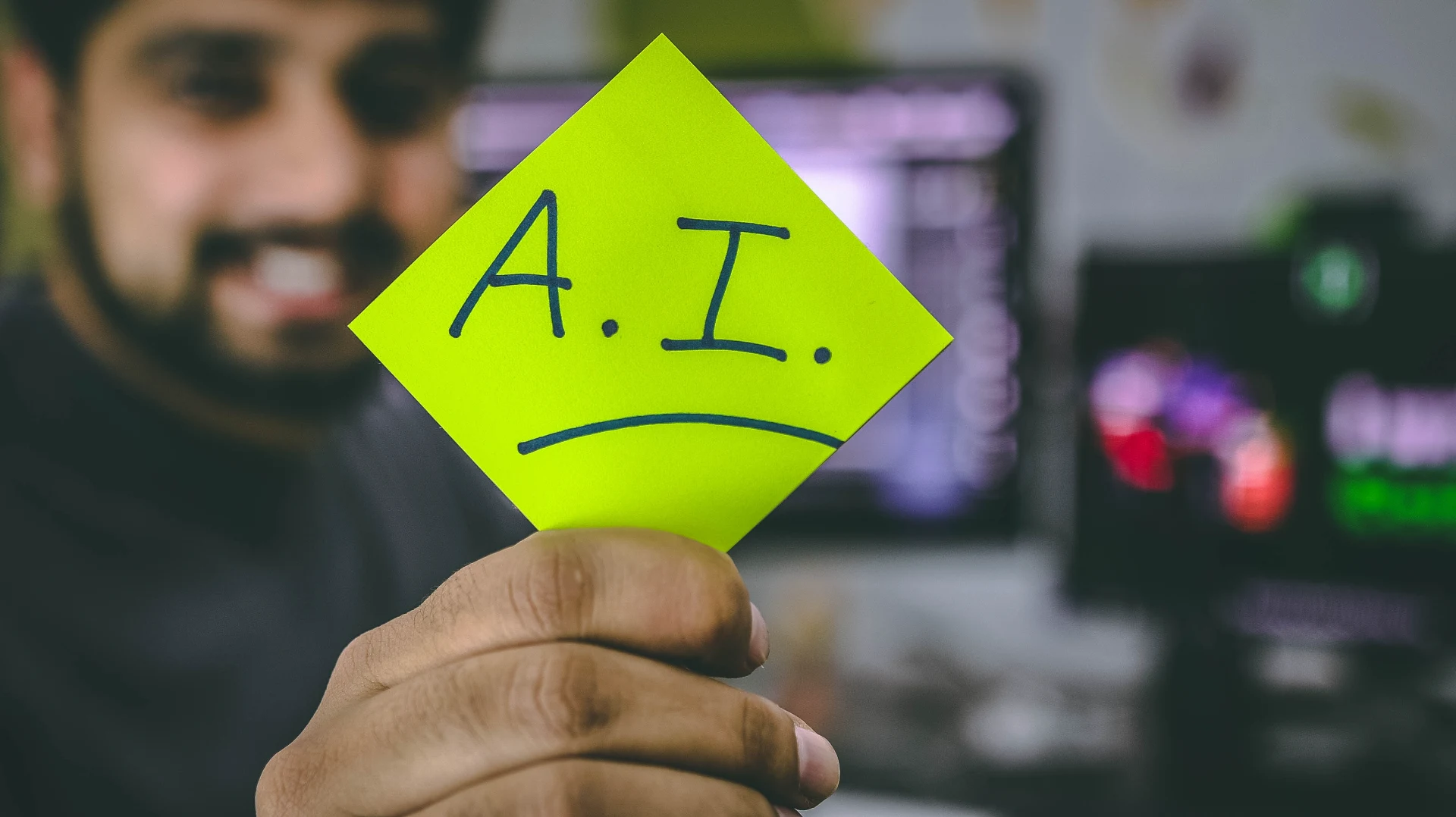 developer holding a post-it with AI written on it